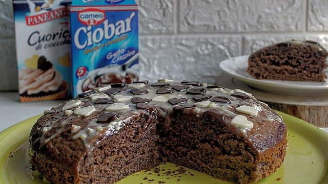 moso aggiungere il burro, poi il latte, continuare a mixsare poi aggiungere la farina poco alla volta ed infine le due bustine di ciobar ( sempre l’una alla volta)per ultimo aggiungere il lievito una volta amalgamato bene gli ingredienti trasferire il composto in uno stampo a cerniera di 24cm infornare a 160g per 35 minuti fare sempre la prova stecchino decorare con glassa di cioccolato bianco fuso e cuori
