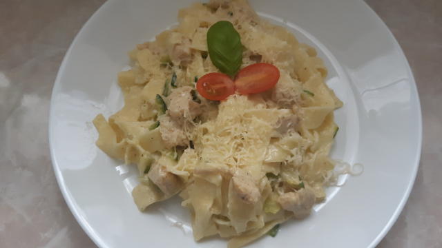 a maśle kurczaka pokrojonego w kostkę i cukinię pokrojoną w paski. Doprawić solą i pieprzem. Smażyć ok 5 min, wrzucić makaron i wlać śmietanę. Gotować ok 2 min albo do czasu aż zgęstnieje.